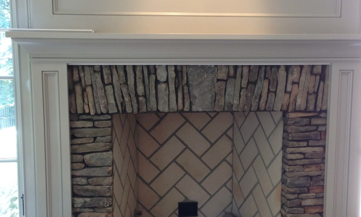 From the granite counter top/ island in the kitchen to this stacked stone fireplace in the hearth room the different gray paint colors flow from room to room.